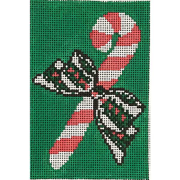 A festive Christmas needlepoint canvas featuring a red and white striped candy cane crossed with a black, white, and green patterned bow, set against a solid green background.